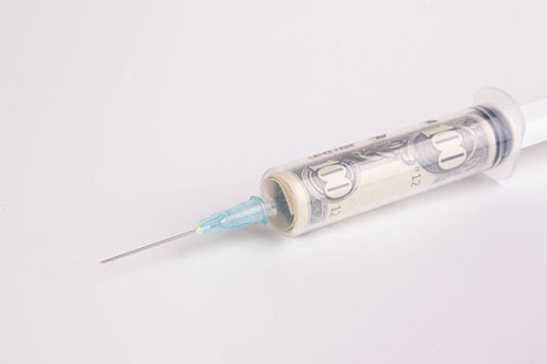 Money in syringe on white background by Marco Verch